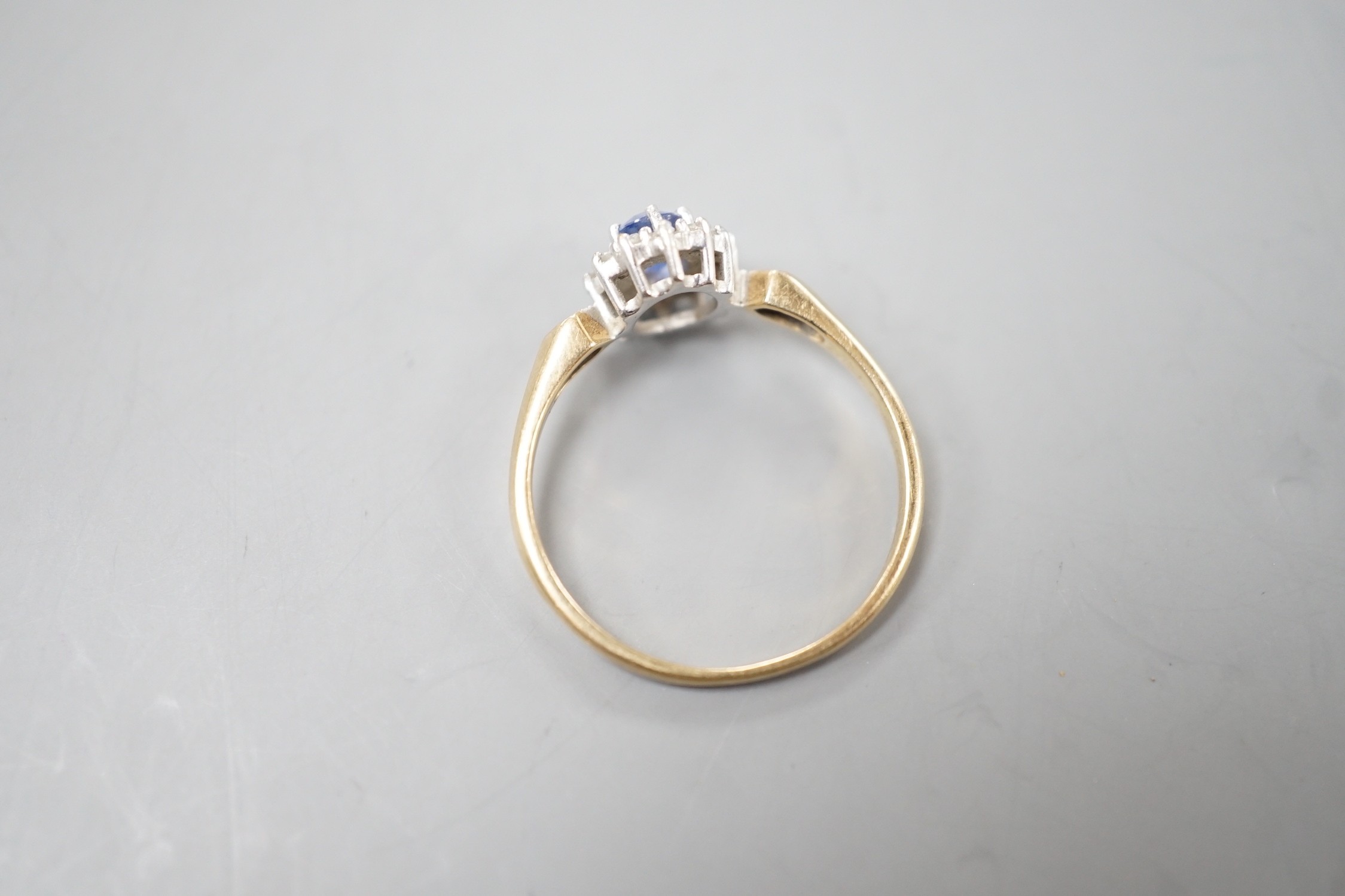 A modern 9ct gold, sapphire and diamond set cluster ring, size R, gross 2.3 grams.